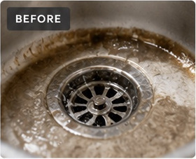 Before drain cleaning: a dirty drain with soap residue and debris