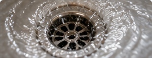 Metal sink drain with flowing water